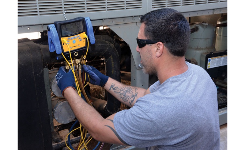 air conditioner technician diagnosing compressor